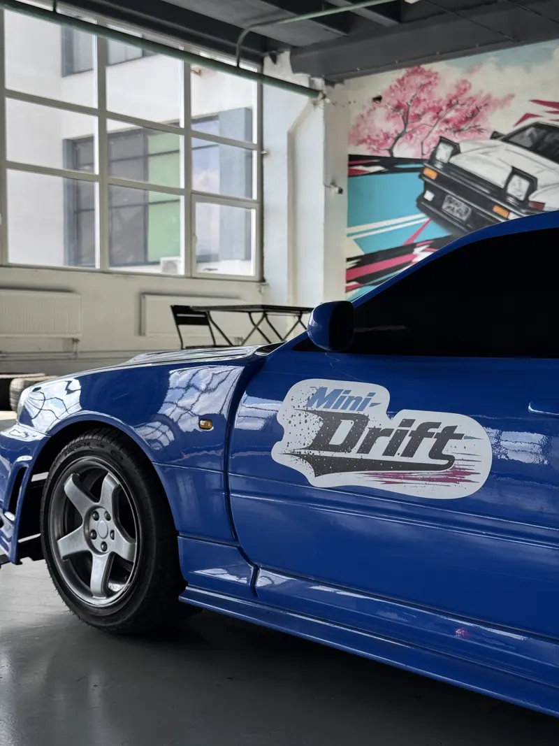 Синяя мини-машина в кузове Nissan Skyline с наклейкой Mini Drift