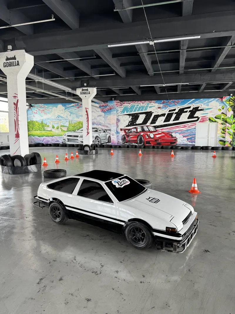 Белая мини-машина в кузове Toyota AE86 у граффити Mini Drift